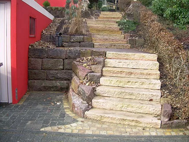 Massive Sandstein-Blockstufen und Natursteine zur Hangüberwindung neben Wohnhaus